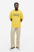 Load image into Gallery viewer, H&amp;M Relaxed Fit T Shirt Yellow/Keith Haring
